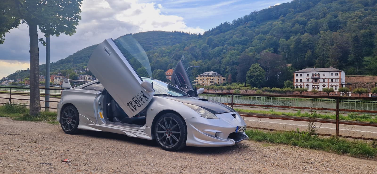 Toyota Celica Silber mit Flügeltüren vor Bergkulisse